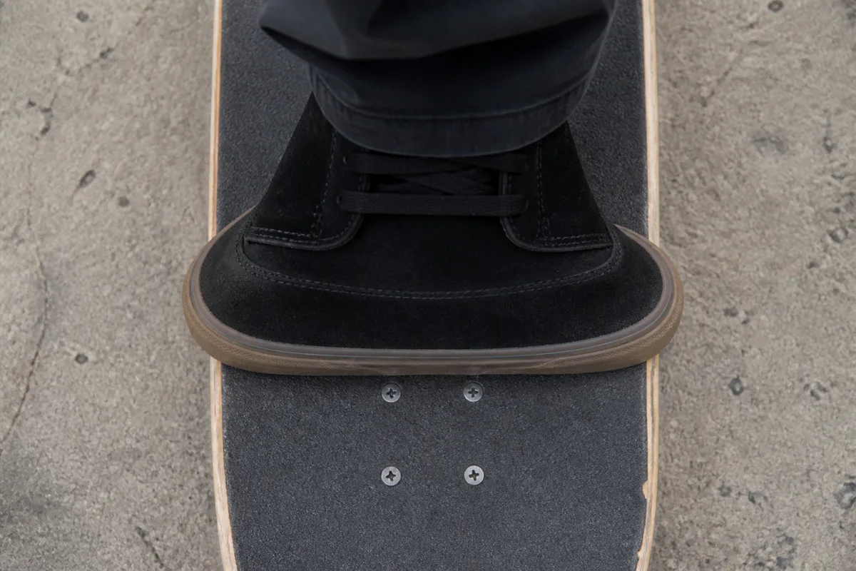 Pied de skateur posé en travers sur la largeur d’une planche pour vérifier le débord